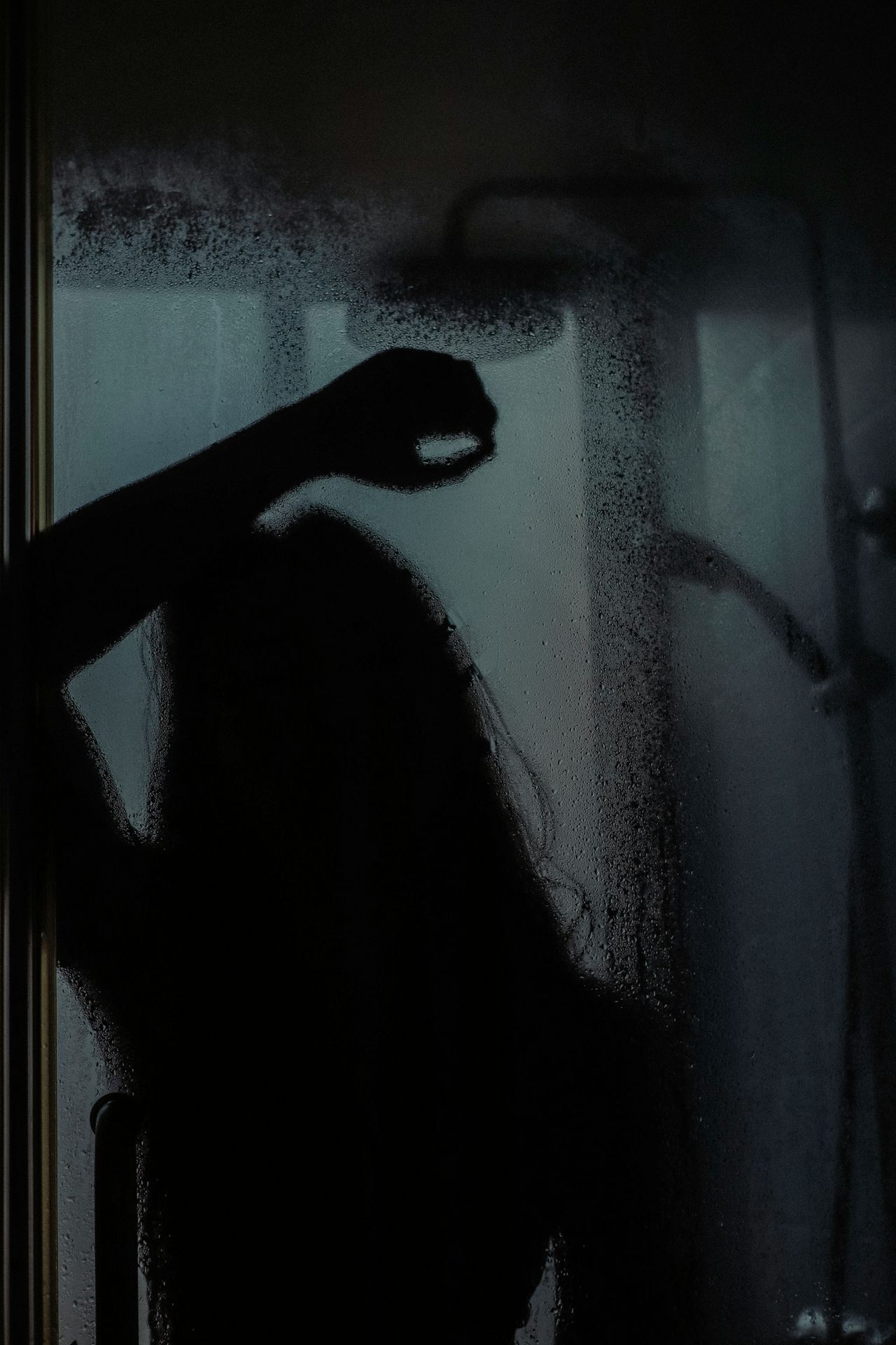 woman in black long sleeve shirt standing in front of glass window